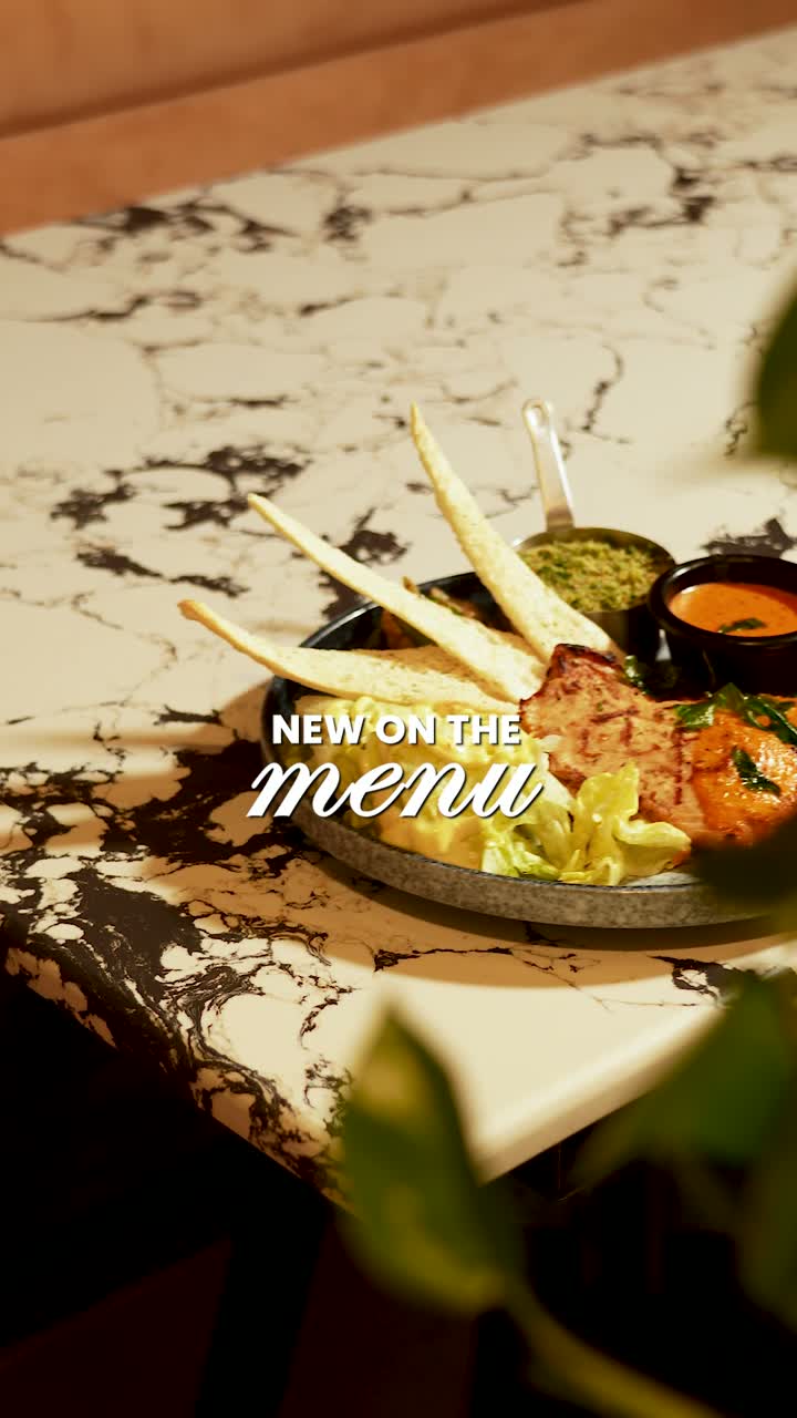 A plated dish on a marble table at Meat The Cheese